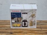 a box with a blender sitting on a wooden table