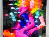 photo encadrée représentant deux femmes aux couleurs fluo assises sur un canapé