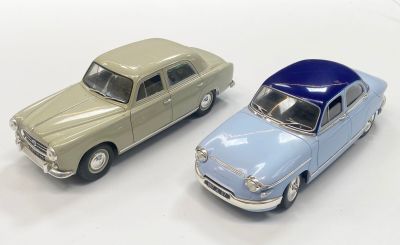 two toy cars sitting next to each other on a white surface