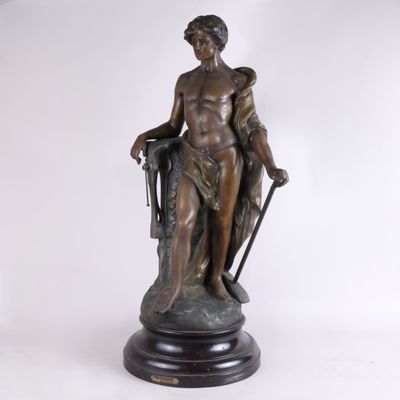 statue en bronze représentant une femme tenant un bâton et un sac
