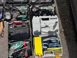 beaucoup d'outils posés par terre à côté d'une voiture