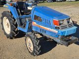 a blue tractor that is parked in the dirt