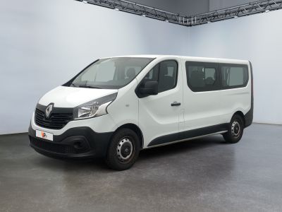La camionnette blanche est garée à l'intérieur d'un grand bâtiment blanc.