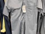 a lot of shirts hanging on a rack in a store