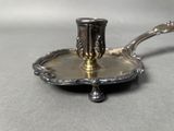 a silver plate with a silver candle holder on it