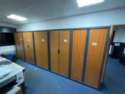 a room with a bunch of wooden doors and a printer on the desk