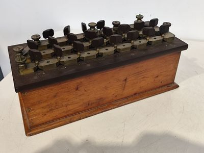 une boîte en bois sur laquelle sont fixés plusieurs boutons