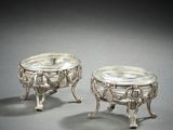paire de plats argentés sur socles, sur fond gris