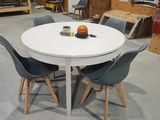 une table blanche entourée de quatre chaises dans une pièce
