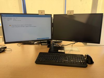 two computer monitors and a keyboard on a desk