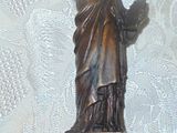 une statue de la Liberté posée sur un socle en bois, elle-même posé sur une table