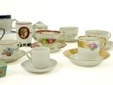 many cups and saucers sitting on a white table