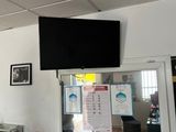 a picture of a kitchen with a television on the wall