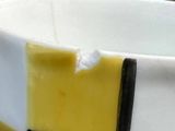 a white bowl with yellow and black stripes on it