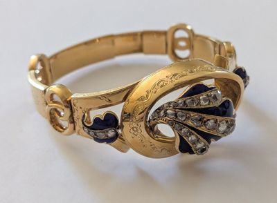 une photo en gros plan d'un bracelet en or orné de pierres bleues et blanches