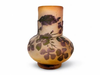 un vase orné de fleurs violettes sur un fond blanc