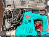 une perceuse électrique bleue rangée dans une mallette à outils