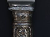 a close up of a silver spoon with a heart on it