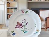 a white plate with a floral design on it sitting on a table