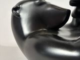 a black sculpture of a dog and a cat on a table
