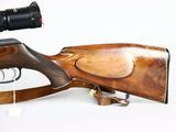 the rifle is sitting on a wooden stand with a red dot on it ' s sight