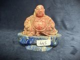 a figurine of a buddha sitting on top of a rock