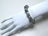 une main de mannequin blanche portant un bracelet