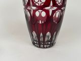 a red vase with white dots on it sitting on a table