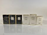 a group of four perfumes sitting on top of a white table