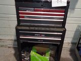 une armoire à outils sur laquelle sont posés des outils, dans un garage