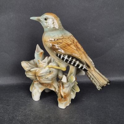 Groupe en porcelaine polychrome représentant un oiseau au ni…