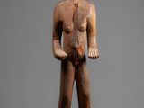 a wooden statue of a man with a hat on his head