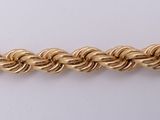 a close up of a gold chain on a white surface