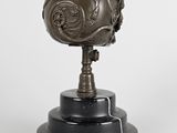 statue of a bronze globe on a marble base on a white background