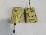 two toy tanks sitting next to each other on a table
