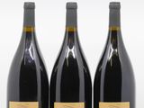 trois bouteilles de vin posées les unes à côté des autres sur une surface blanche