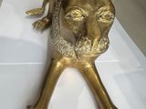 a gold statue of a lion laying on a white table