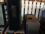 a black refrigerator sitting on a pallet next to other appliances