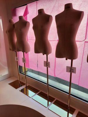 trois mannequins exposés devant une vitrine dans une pièce rose