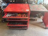 un établi rouge sur lequel sont posés des outils, dans un garage