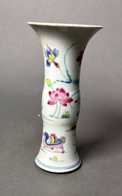 a white vase with flowers on it sitting on a table