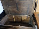 a wooden chest that is open on the floor