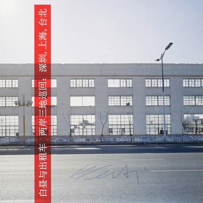 a red sign on the side of the road in front of a building