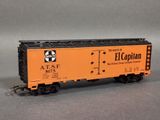 an orange and black train car sitting on top of a gray surface