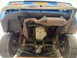 a blue car with a big exhaust pipe under it