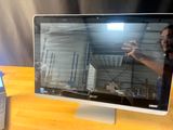 un homme en train de prendre une photo de l'écran d'un ordinateur posé sur un bureau
