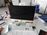 a computer monitor sitting on top of a desk next to a keyboard