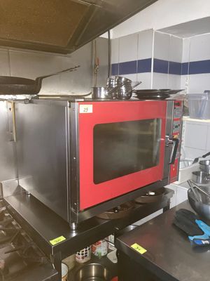 un micro-ondes rouge posé sur une cuisinière dans une cuisine