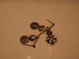 a pair of earrings sitting on top of a white table