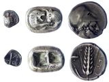 several silver coins with faces and ears on them on a white surface